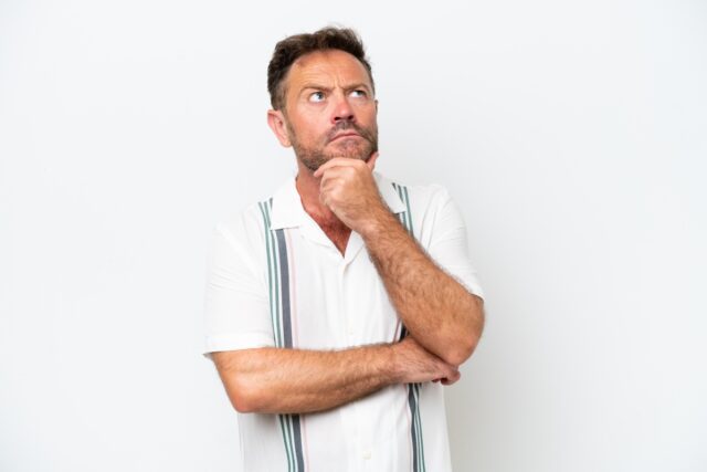 Mężczyzna w średnim wieku zastanawia się nad czymś. Przyjmuje pozycje myśliciela. Po jego minie widać, że myśli nad czymś co nie daje mu spokoju.