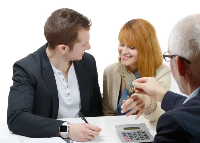 Kobieta i mężczyzna podpisują dokument. Oboje są zadowoleni.