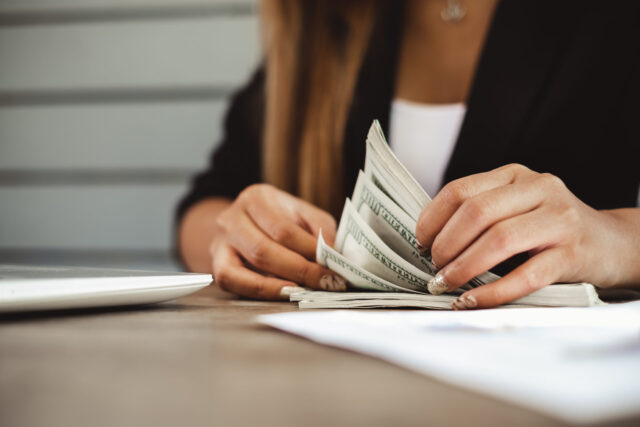 Kobieta przegląda dokumenty. Zbliżenie na kobiece dłonie.